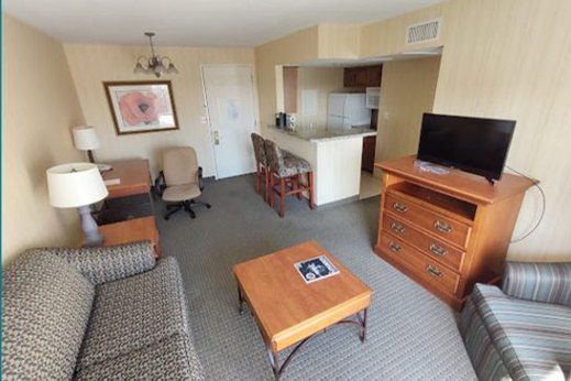 Suite interior before renovation, with dated furnishings and carpet